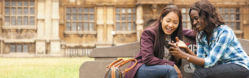 Two postgraduate students looking at a phone