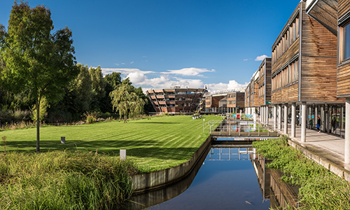 Lake, grassland and buildings at Jubilee Campus