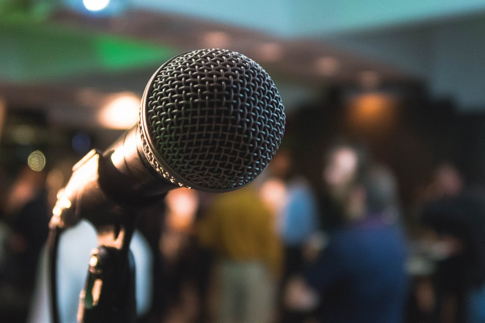 Microphone in foreground with a crowd behind