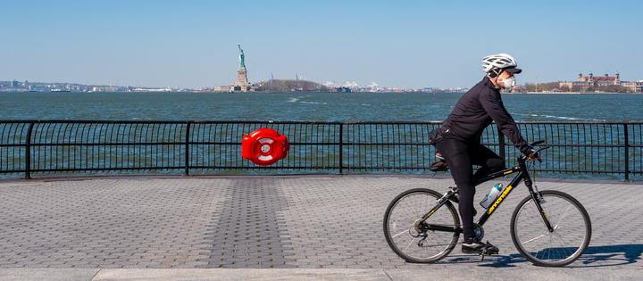 Man riding a bike with a mask on