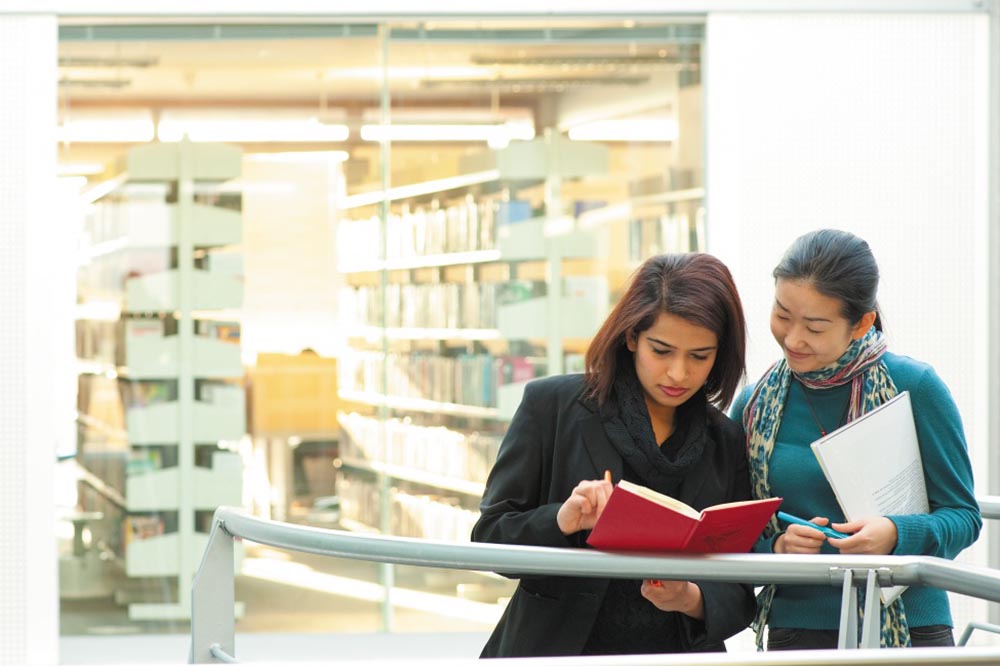 Image of two postgraduate students stood outside the Business Library