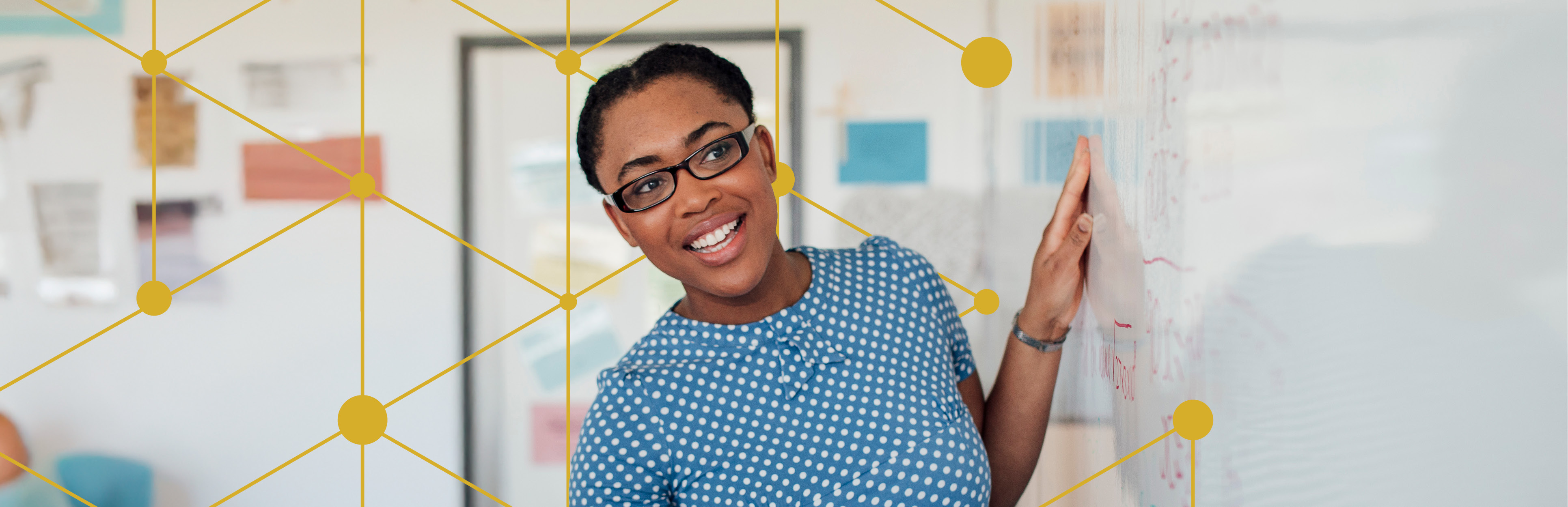 female maths teacher standing at front of classroom in front of a whiteboard with maths question