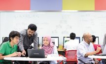 A lecturer helping students with a task