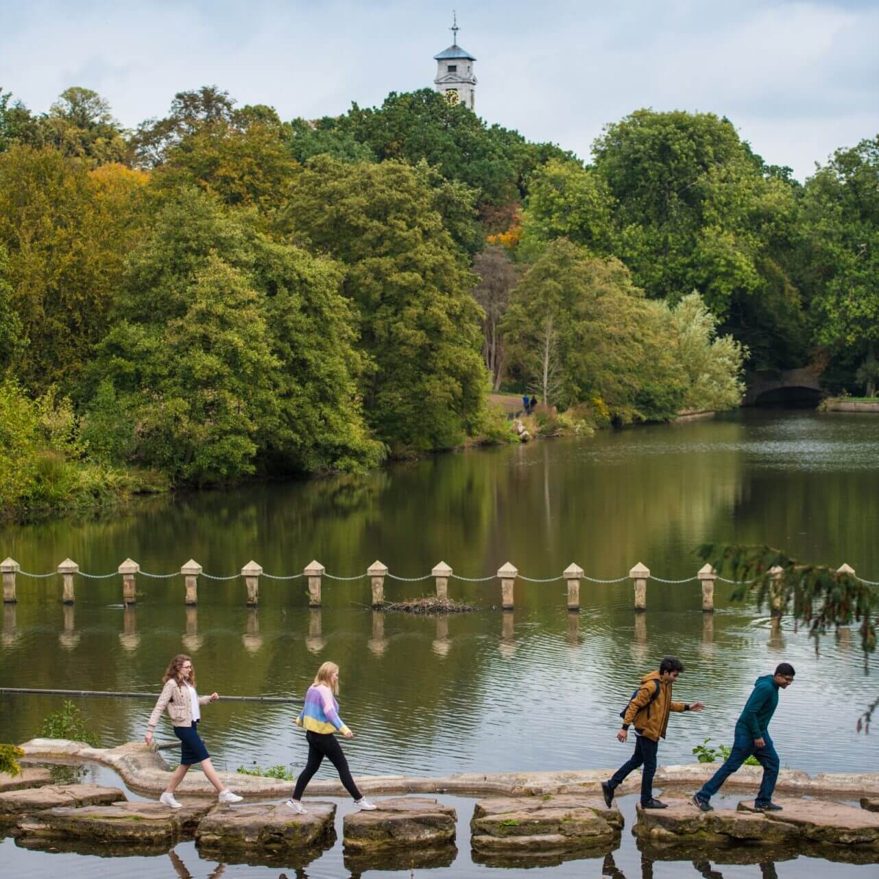 Undergraduate students walking over stepping stones