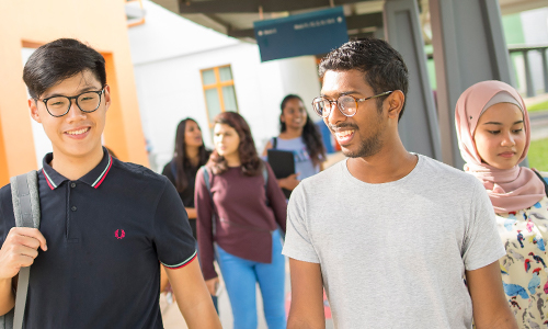 International students walking on a covered footpath on campus