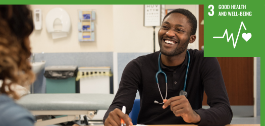 Medical professional sitting at a table having a conversation with another person