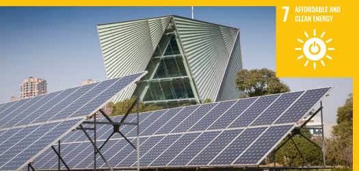 Two rows of solar panels in front of a building
