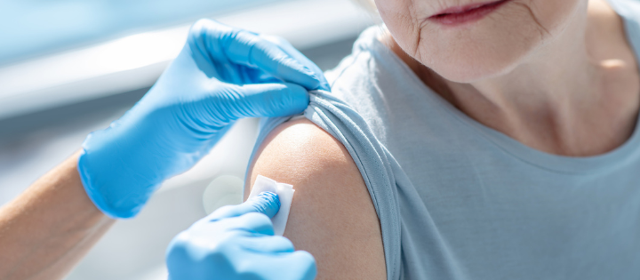 Pharmacist wiping an elderly women's arm ready for a vaccine