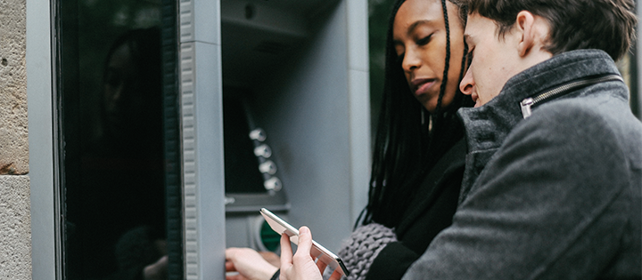Two people using a cash machine