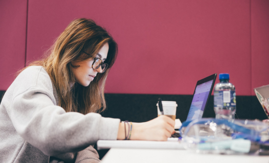 Photo of a student writing notes into a notepad.