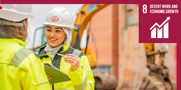 Engineer wearing blue overalls and yellow helmet, operating a large machine
