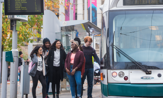 Group of students waiting at a tram stop